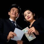 契約書と請求書を手に持った夫婦の黒い背景の画像